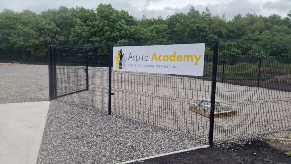 The Aspire Academy site with the Aspire Academy banner on the black metal fencing